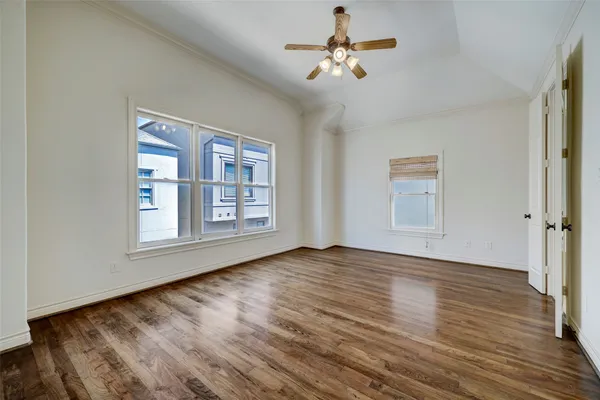 a view of an empty room with a window and wooden floor
