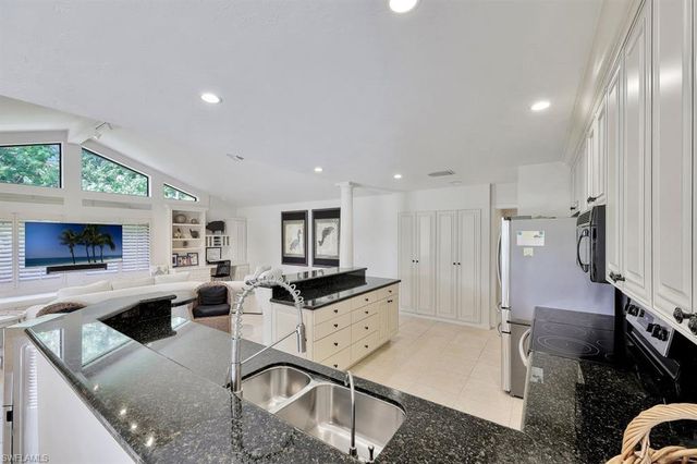 a kitchen with stainless steel appliances granite countertop a sink a stove and a refrigerator