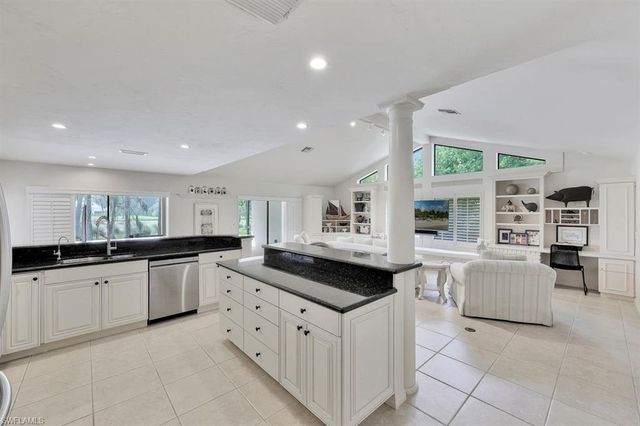 a kitchen with granite countertop white cabinets and stainless steel appliances