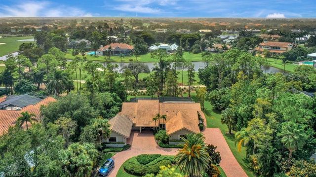 an aerial view of residential houses with outdoor space and trees