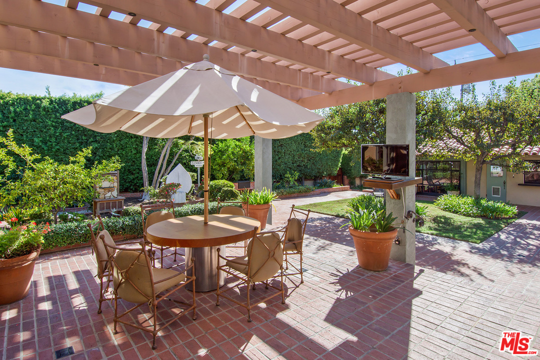 701 North Alpine Drive Beverly Hills, CA 90210 - Photo 20 of 22 a view of a patio with table and chairs under an umbrella