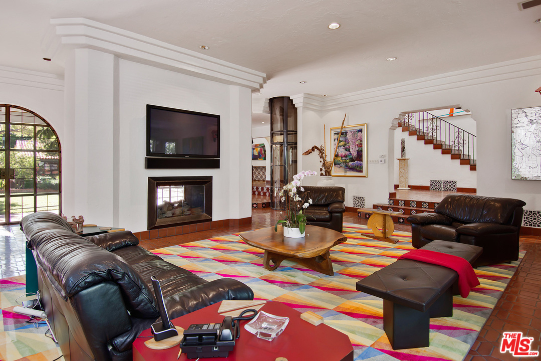 701 North Alpine Drive Beverly Hills, CA 90210 - Photo 6 of 22 a living room with furniture a flat screen tv and a fireplace