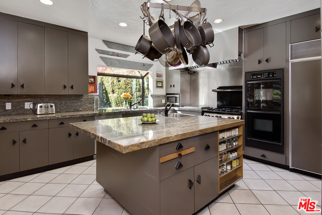 701 North Alpine Drive Beverly Hills, CA 90210 - Photo 10 of 22 a kitchen with stainless steel appliances granite countertop a sink a stove and a refrigerator