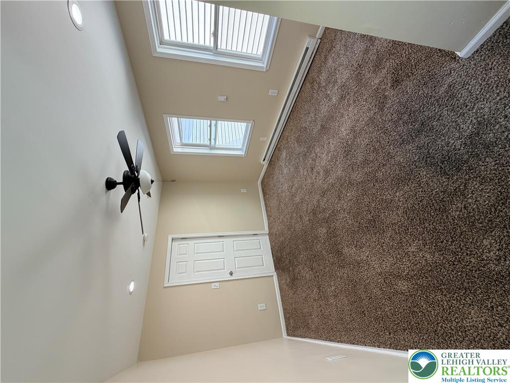 718 Ferry Street Easton, PA 18042 - Photo 12 of 37 Lofty ceilings with a ceiling fan enhance the carpeted interior, illuminated by a skylight.
