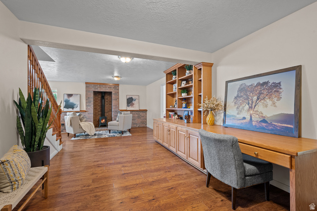 555 East 1700 N Street Mapleton, UT 84664 - Photo 38 of 49 Wood-finish flooring throughout, built-in shelving, wooden staircase with balusters, exposed brick fireplace, and integrated desk