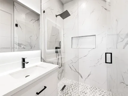a bathroom with a sink a mirror and shower