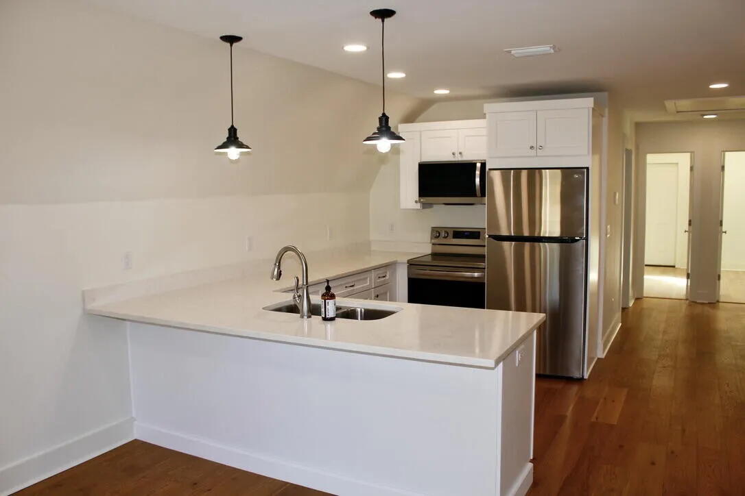 54 Davis Street DeFuniak Springs, FL 32435 - Photo 3 of 14 a kitchen with kitchen island white cabinets and stainless steel appliances