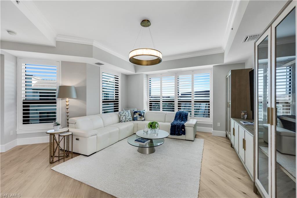 9115 Strada Place, Unit 5502 Naples, FL 34108 - Photo 14 of 48 Living room with built in cabinets for storage and TV , crown molding, and plenty of natural light