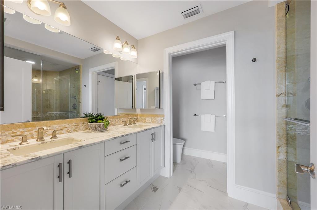 9115 Strada Place, Unit 5502 Naples, FL 34108 - Photo 21 of 48 Updated Full bathroom featuring a stall shower, double vanity, and light marble finish flooring