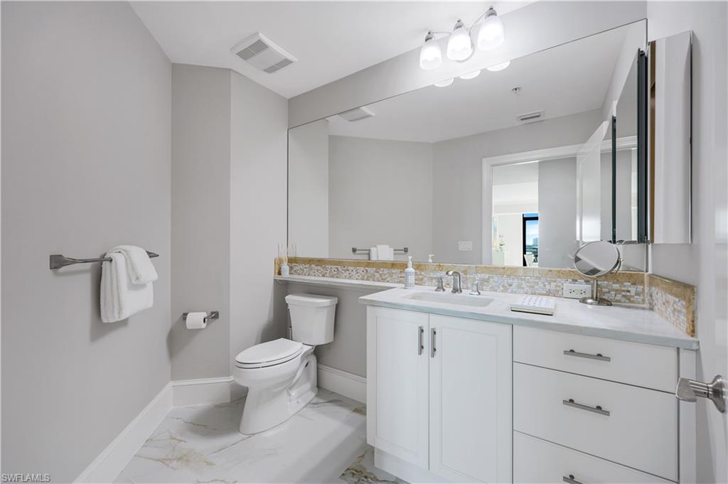 9115 Strada Place, Unit 5502 Naples, FL 34108 - Photo 28 of 48 Updated Guest Bathroom with light marble finish flooring and vanity