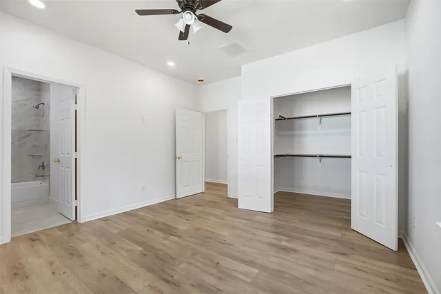 a view of a big room with wooden floor closet and windows