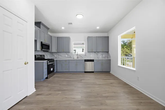 a kitchen with a window stainless steel appliances and cabinets