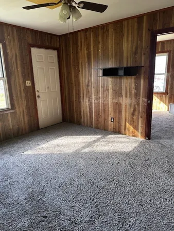 an empty room with a window and a ceiling fan