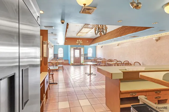 a kitchen with a table chairs stainless steel appliances and cabinets
