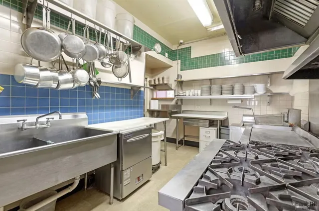 a kitchen with a stove a table and chairs in it