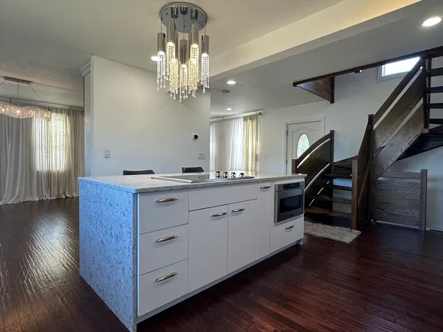 a hallway with white cabinets and wooden floor