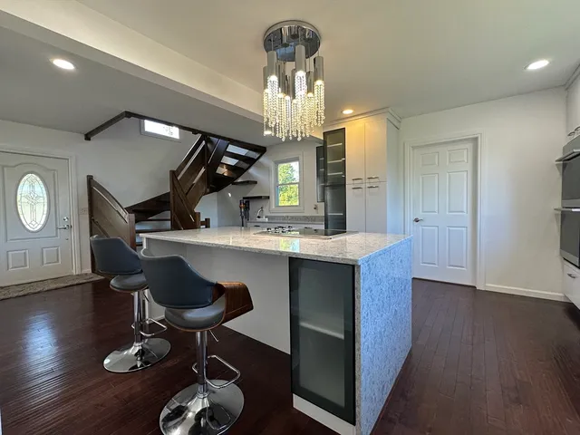 a kitchen with granite countertop a sink cabinets and wooden floor