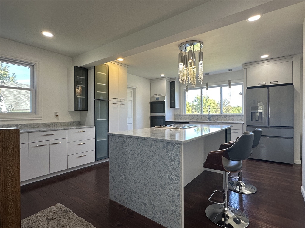 712 Cooper Street Agawam, MA 01001 - Photo 9 of 26 a large kitchen with granite countertop a large island in the center a sink a window stainless steel appliances and furniture