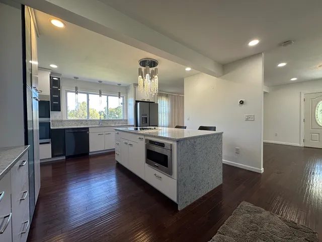 a kitchen with stainless steel appliances a stove top oven and refrigerator