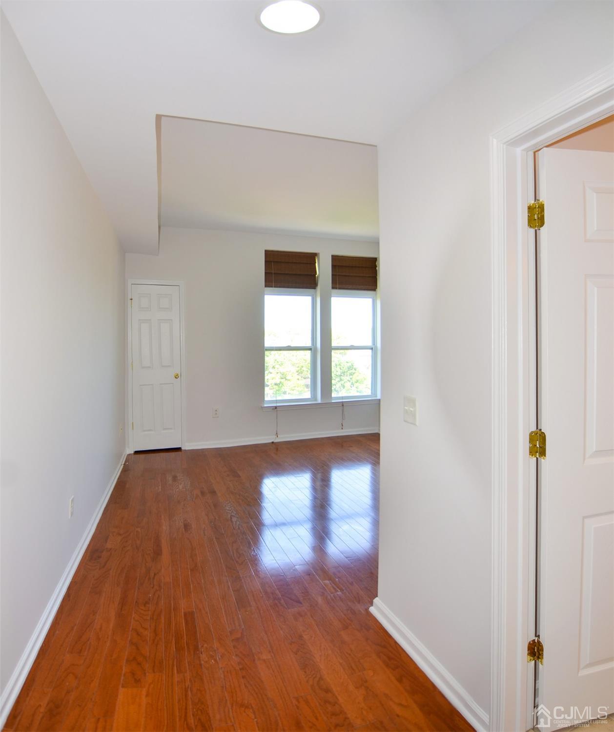 358 Rector Street, Unit 703 Perth Amboy, NJ 08861 - Photo 20 of 25 a view of an empty room with wooden floor and a window