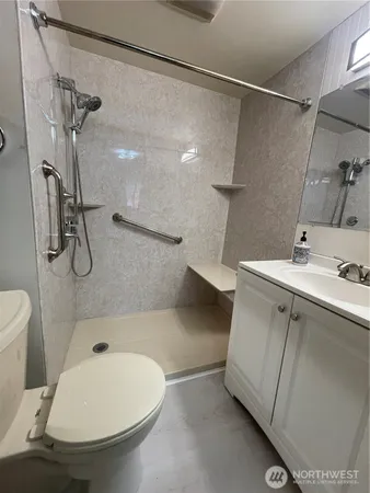a bathroom with a sink a toilet and shower