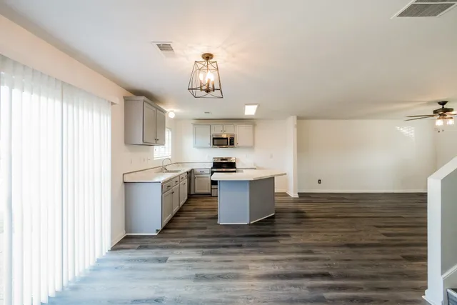 a large kitchen with a lot of cabinets and wooden floor