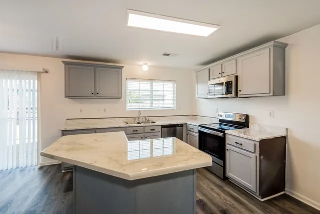 a kitchen with a stove a sink a microwave and wooden cabinets