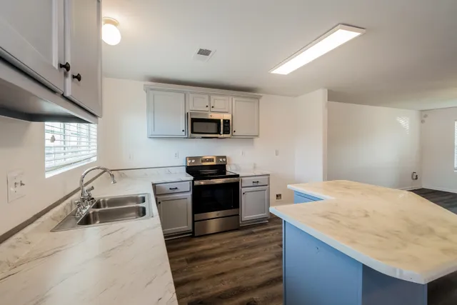 a kitchen with a stove a sink and a microwave