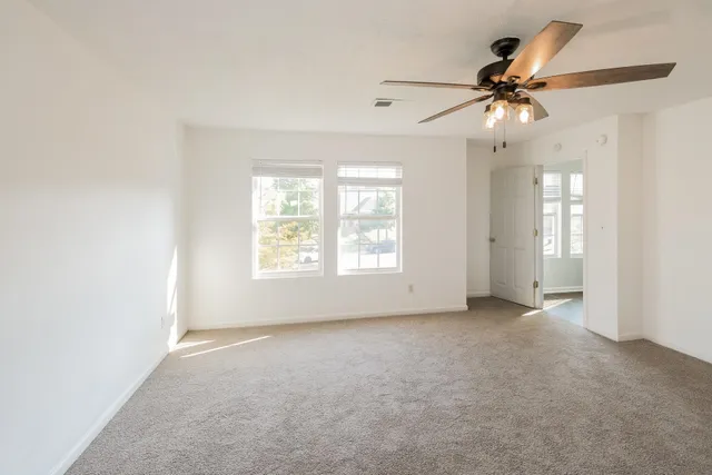 an empty room with fan and windows