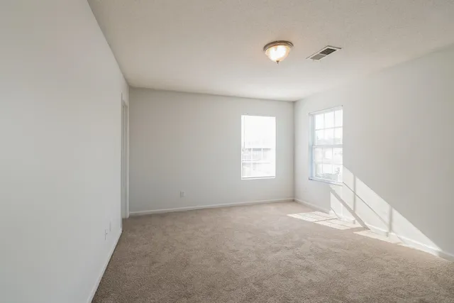 an empty room with windows and closet
