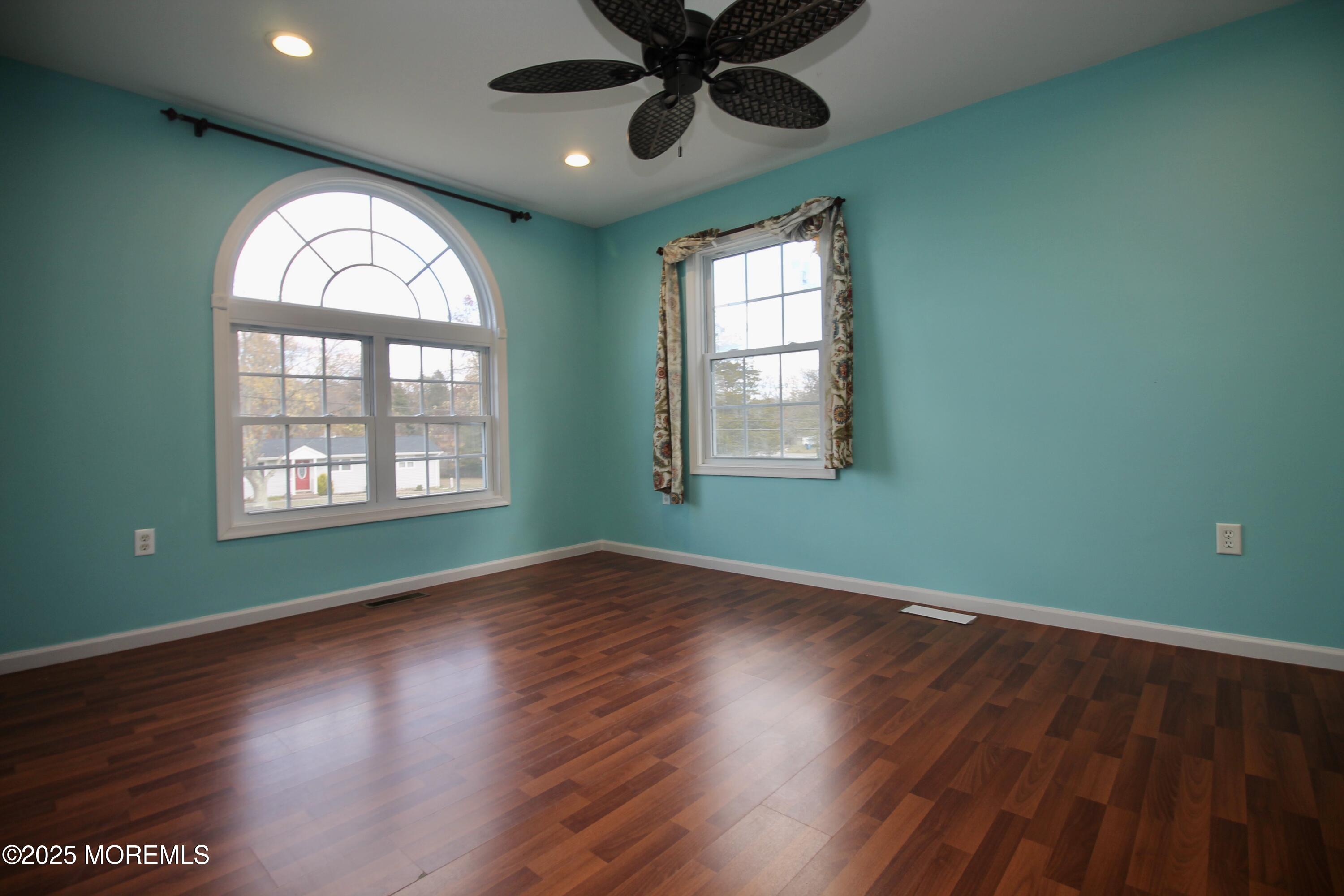 16 Maple Lane Howell, NJ 07731 - Photo 31 of 55 an empty room with wooden floor windows and a ceiling fan