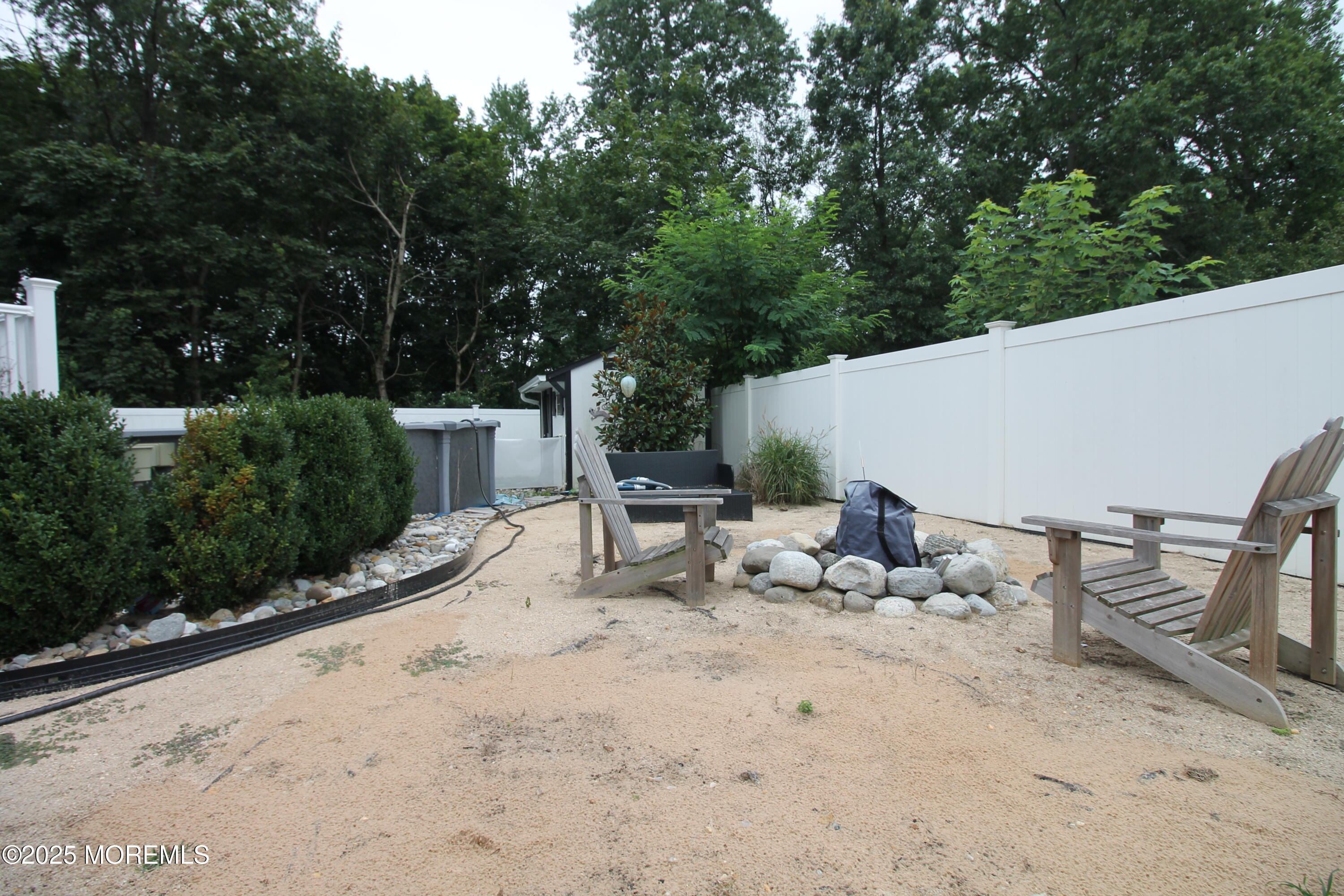 16 Maple Lane Howell, NJ 07731 - Photo 49 of 55 a view of backyard with a table and chairs with wooden fence and plants