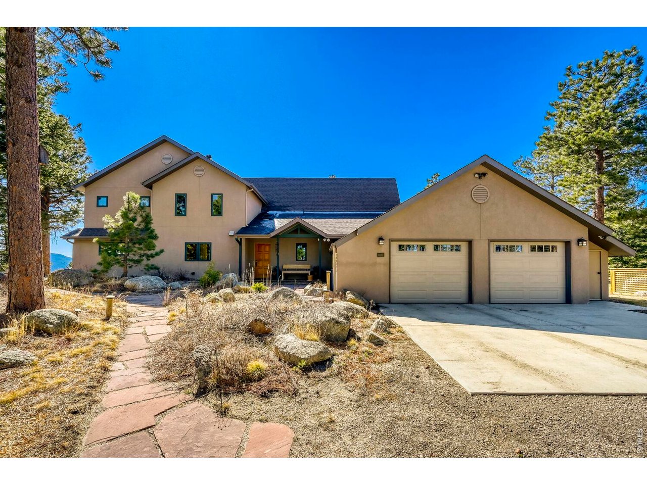 6010 Flagstaff Road Boulder, CO 80302 - Photo 34 of 41 Back outside of the house, garage, concrete driveway and the Colorado blue sky