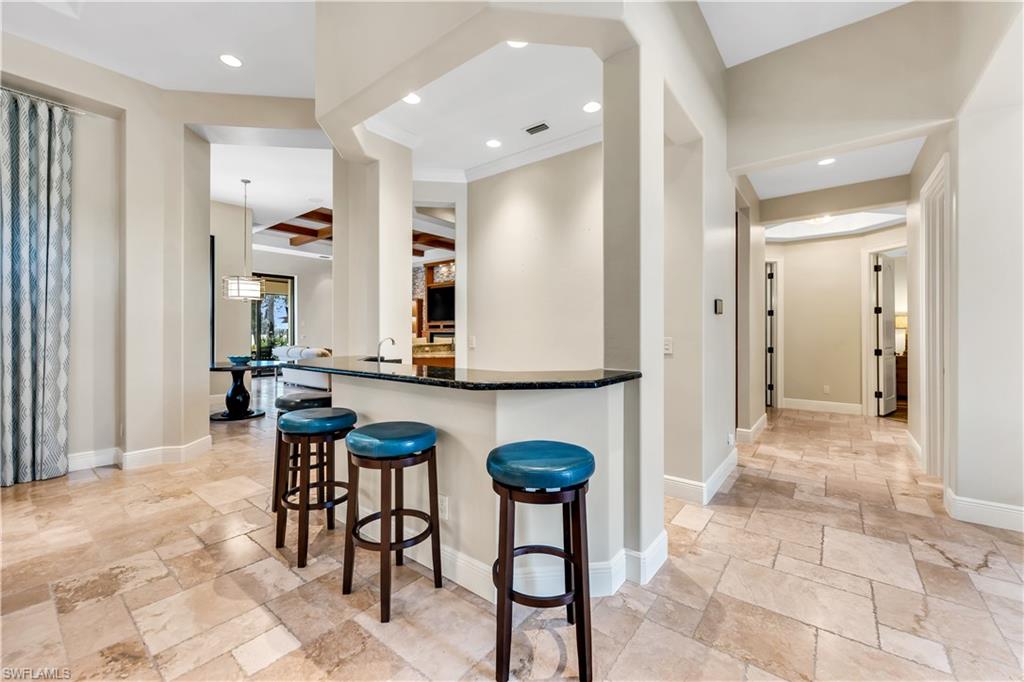 11875 Hedgestone Court Naples, FL 34120 - Photo 6 of 29 Built-in bar with dark countertop and recessed lighting, archways, and tile flooring