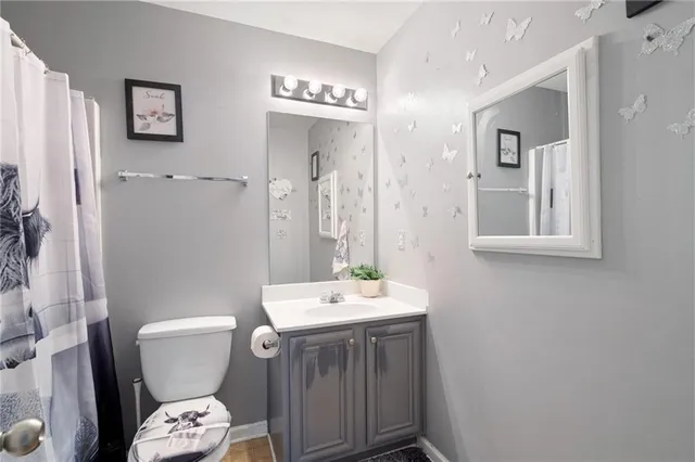 a bathroom with a sink a toilet a mirror and shower