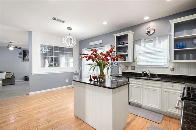 a kitchen with granite countertop a sink cabinets and window