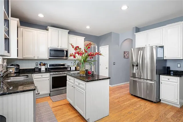 a kitchen with granite countertop a refrigerator sink and microwave