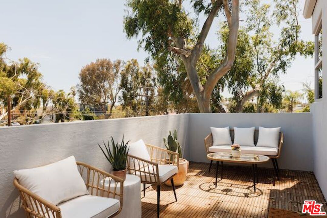 1523 Cabrillo Avenue Venice, CA 90291 - Photo 14 of 22 a roof deck with a table and chairs with wooden fence