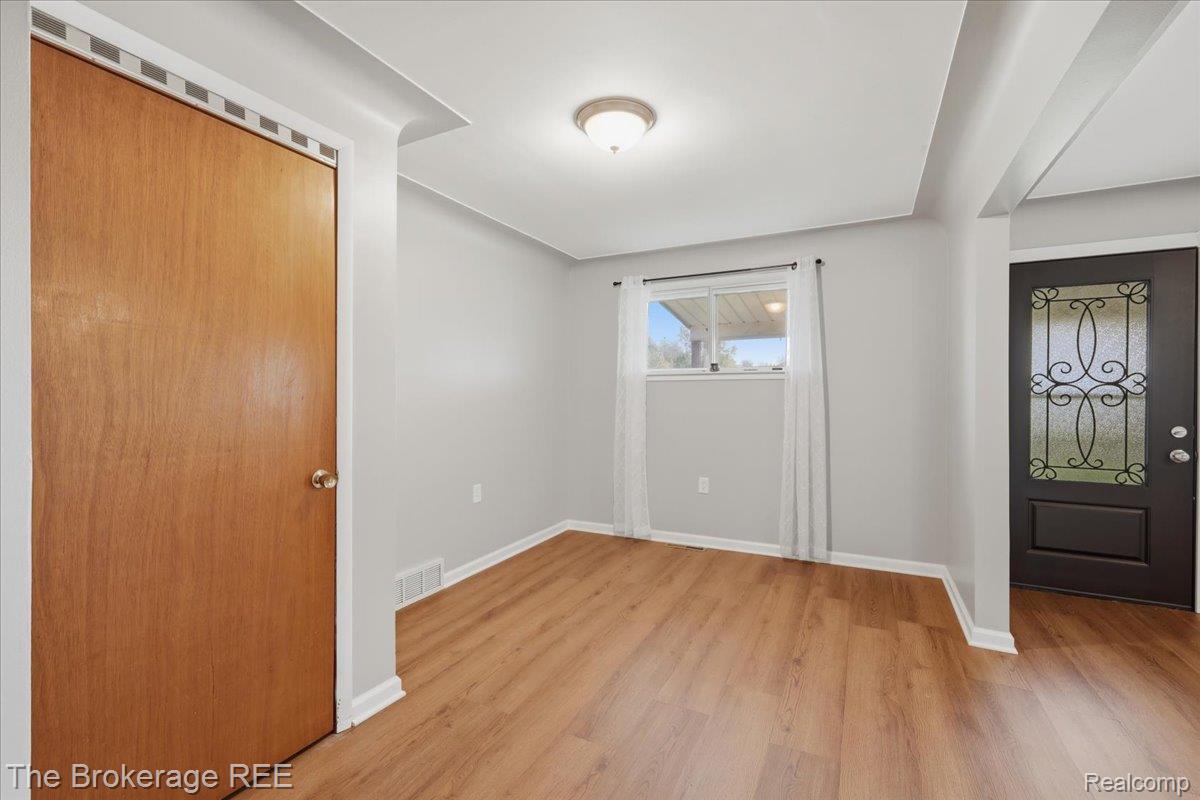 11973 East Brooks Road Lennon, MI 48449 - Photo 12 of 28 Wood-finish flooring, light gray wall tones, recessed ceiling detail, ceiling-mounted light fixture, and a front entry door with decorative glass