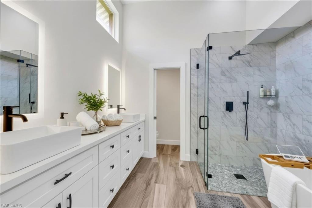 123 Napa Ridge Way Naples, FL 34119 - Photo 16 of 30 a spacious bathroom with sink shower and mirror