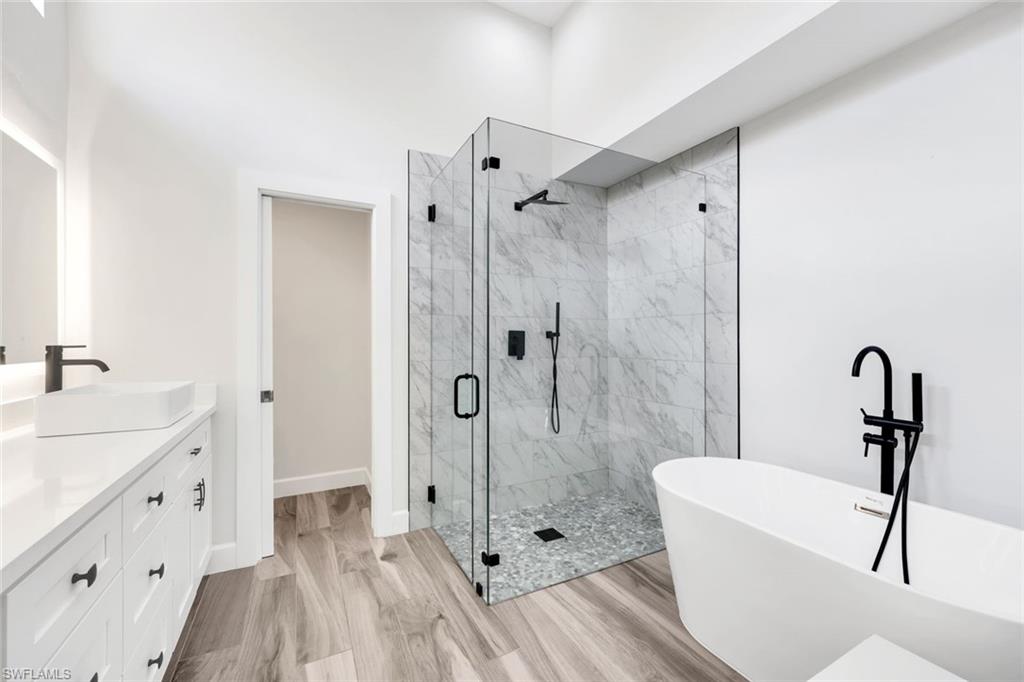 123 Napa Ridge Way Naples, FL 34119 - Photo 17 of 30 a bathroom with a sink a toilet a mirror and shower