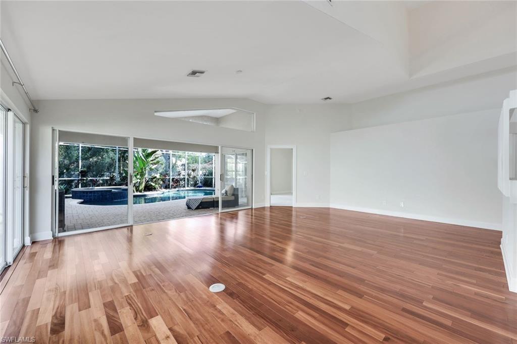 123 Napa Ridge Way Naples, FL 34119 - Photo 9 of 30 a view of an empty room with wooden floor and a window