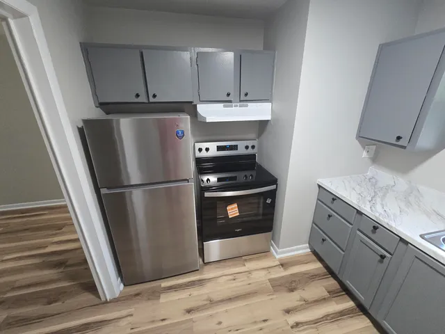 a kitchen with a refrigerator sink and cabinets