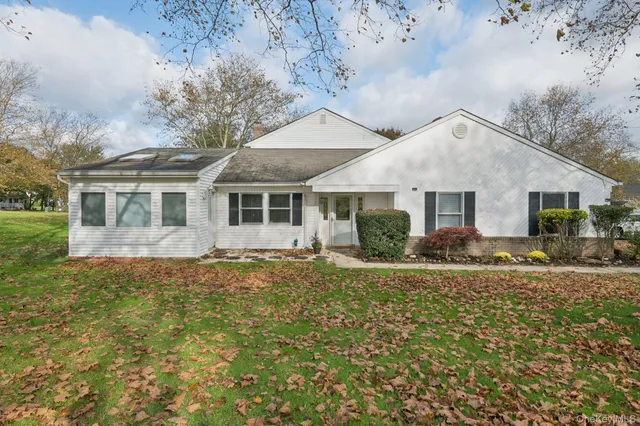 a view of a house with a yard and large tree