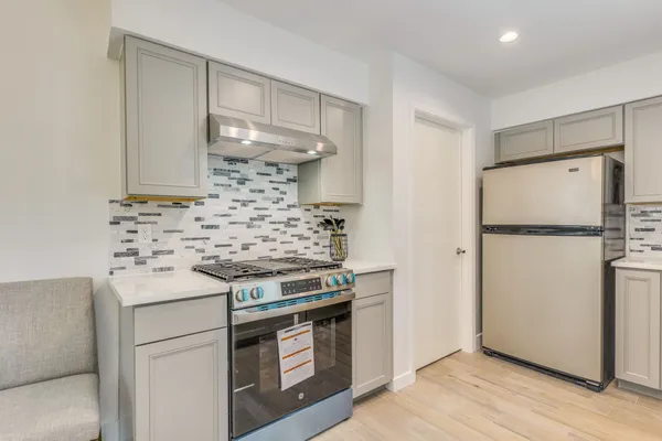 a kitchen with a stove a refrigerator and a sink