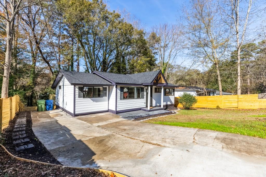 a view of a house with a yard and large tree