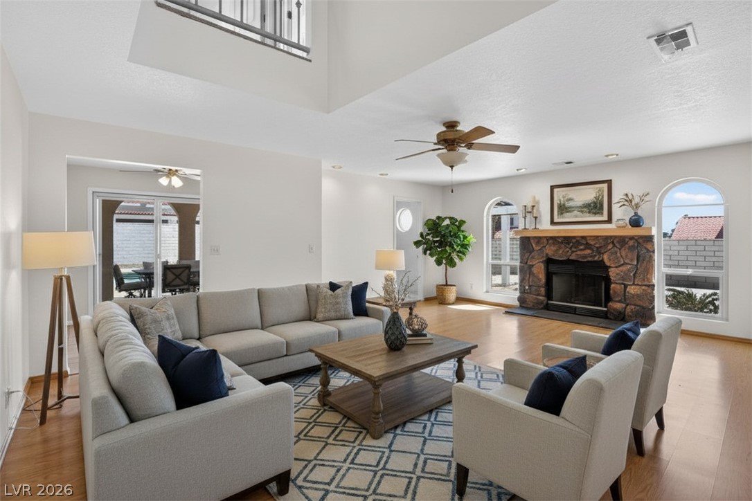 3698 Laughlin Boulevard Laughlin, NV 89029 - Photo 17 of 49 A spacious living area features a stone fireplace, high ceilings, and warm hardwood flooring.
