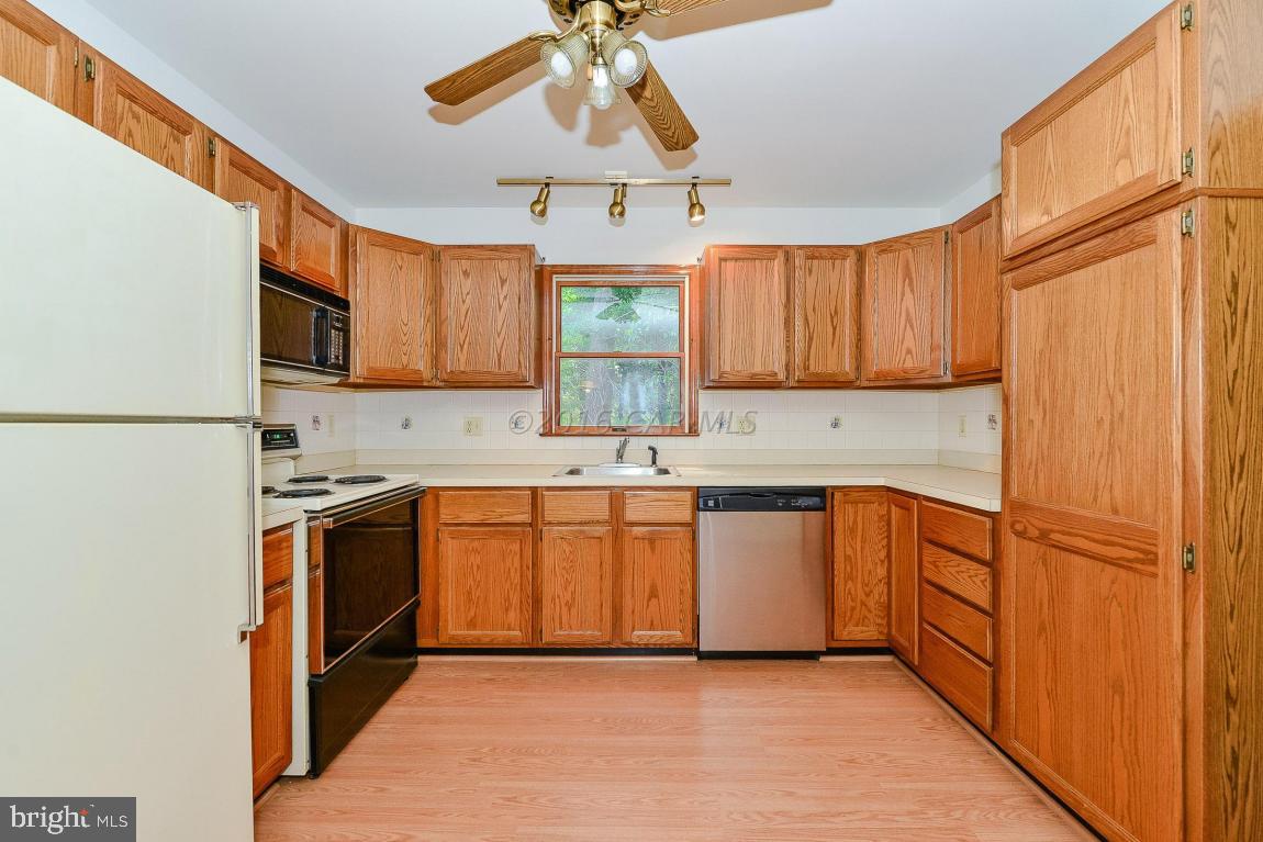 241 Windjammer Road Berlin, MD 21811 - Photo 12 of 38 a kitchen with stainless steel appliances granite countertop a refrigerator a sink dishwasher a stove with wooden cabinets and floor