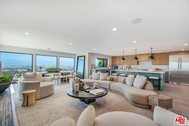 a kitchen with a sink a counter top space and living room view