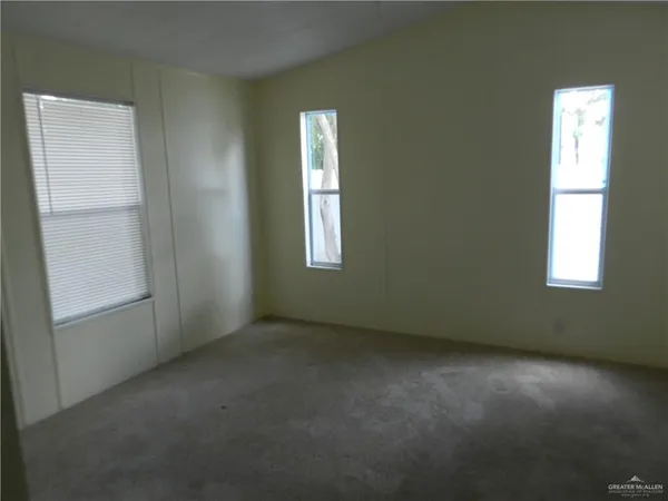 an empty room with windows and closet